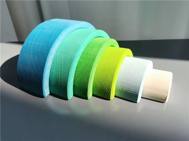 Set of colorful rolls of wooden archs on a gray surface