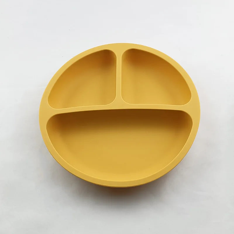 Yellow silicone plate with three sections on a white background
