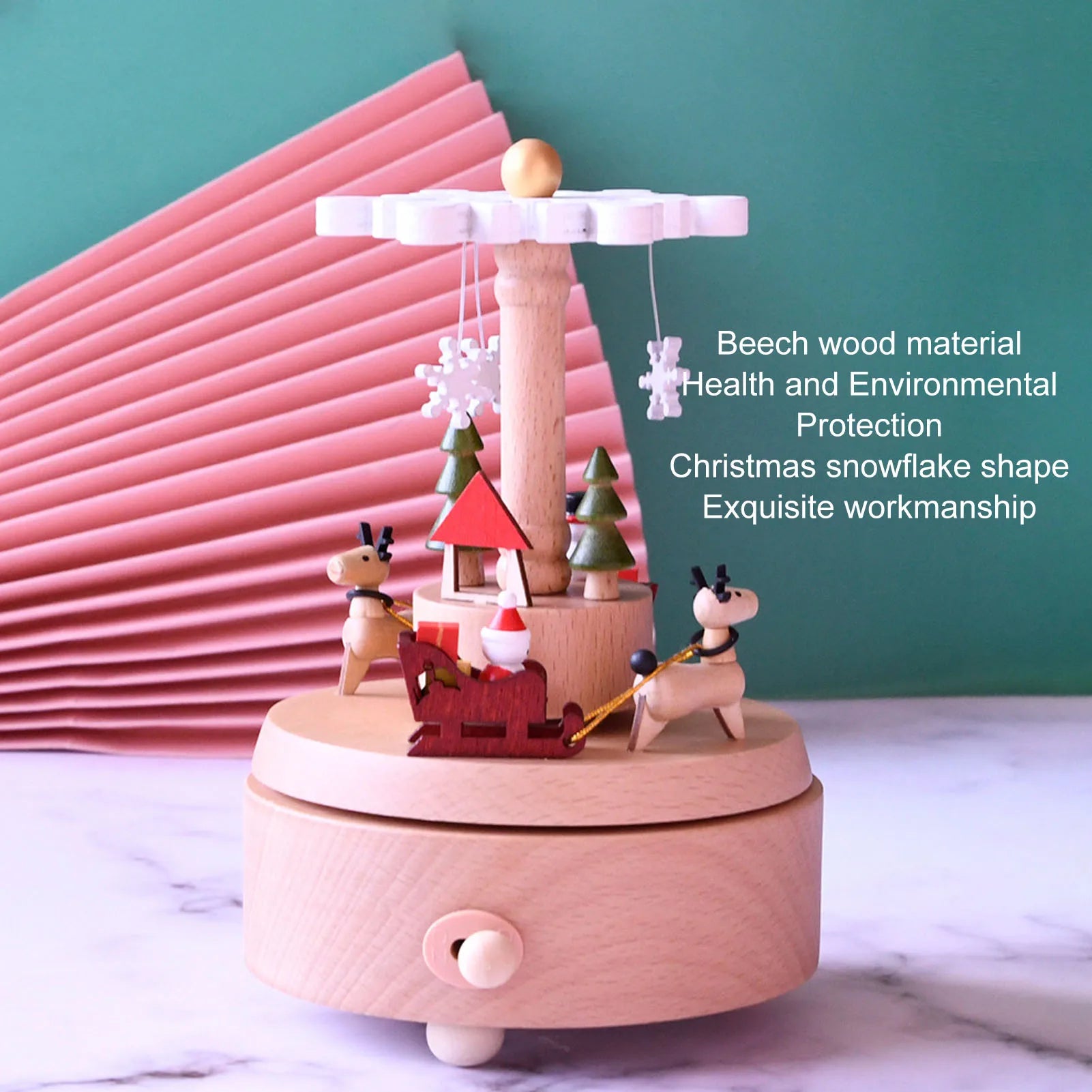 Wooden Christmas-themed music box with pink base on a white surface and green background