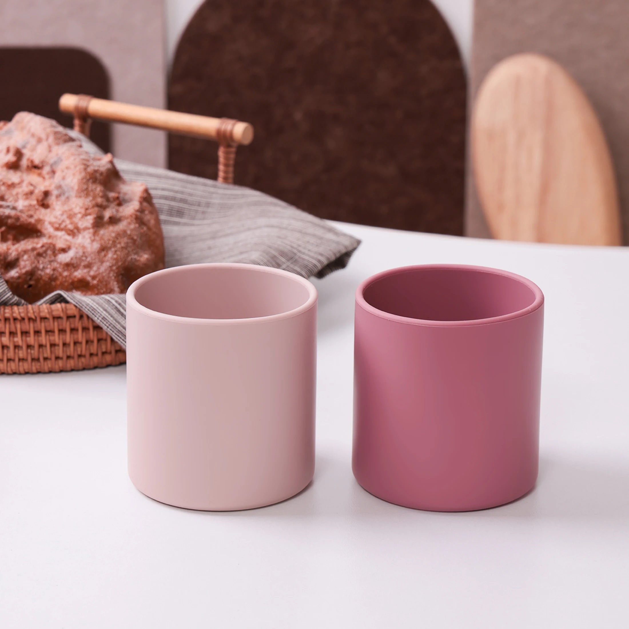 Two pink silicone training cups on a table