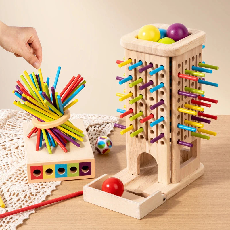 Montessori-inspired wooden stick tower game with colorful sticks, a matching dice, and a color matching box, displayed on a wooden table.
