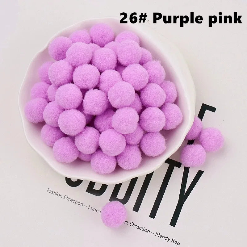 Purple pink pom-poms in a white bowl on a magazine background