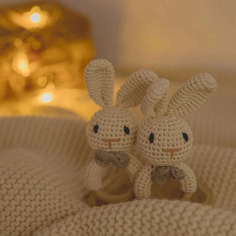 Bunny Woodland Crochet Rattle with knitted bunnies on a blanket, designed for sensory play and early learning from Oliver & Company Montessori Toys.