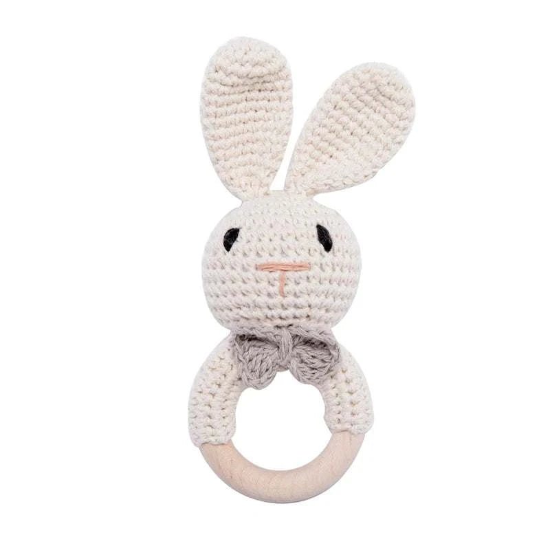 Bunny Woodland Crochet Rattle, a knitted toy with a bunny face, combines soft crochet and wooden elements for sensory exploration. Ideal for infants' tactile development.