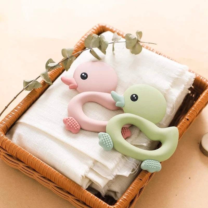 Duck Silicone Teether for Newborns (0-12 Months) in a basket, designed to soothe teething discomfort with its adorable duck shape, ideal for babies to grasp.