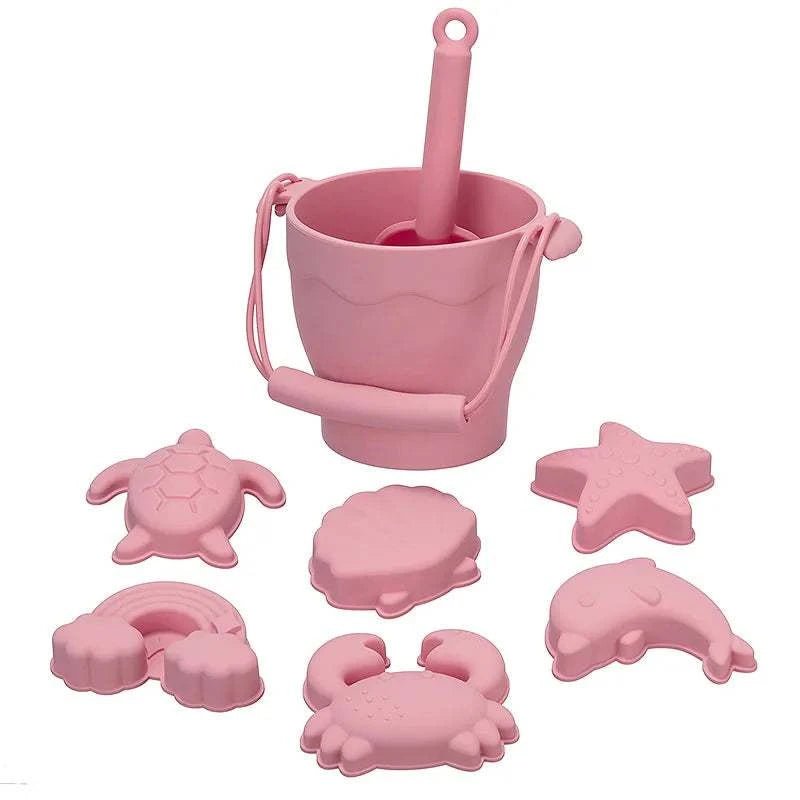 Eco-Friendly Silicone Beach Toys Set with pink bucket and molds in shapes like crab, turtle, and star, perfect for creative beach play.