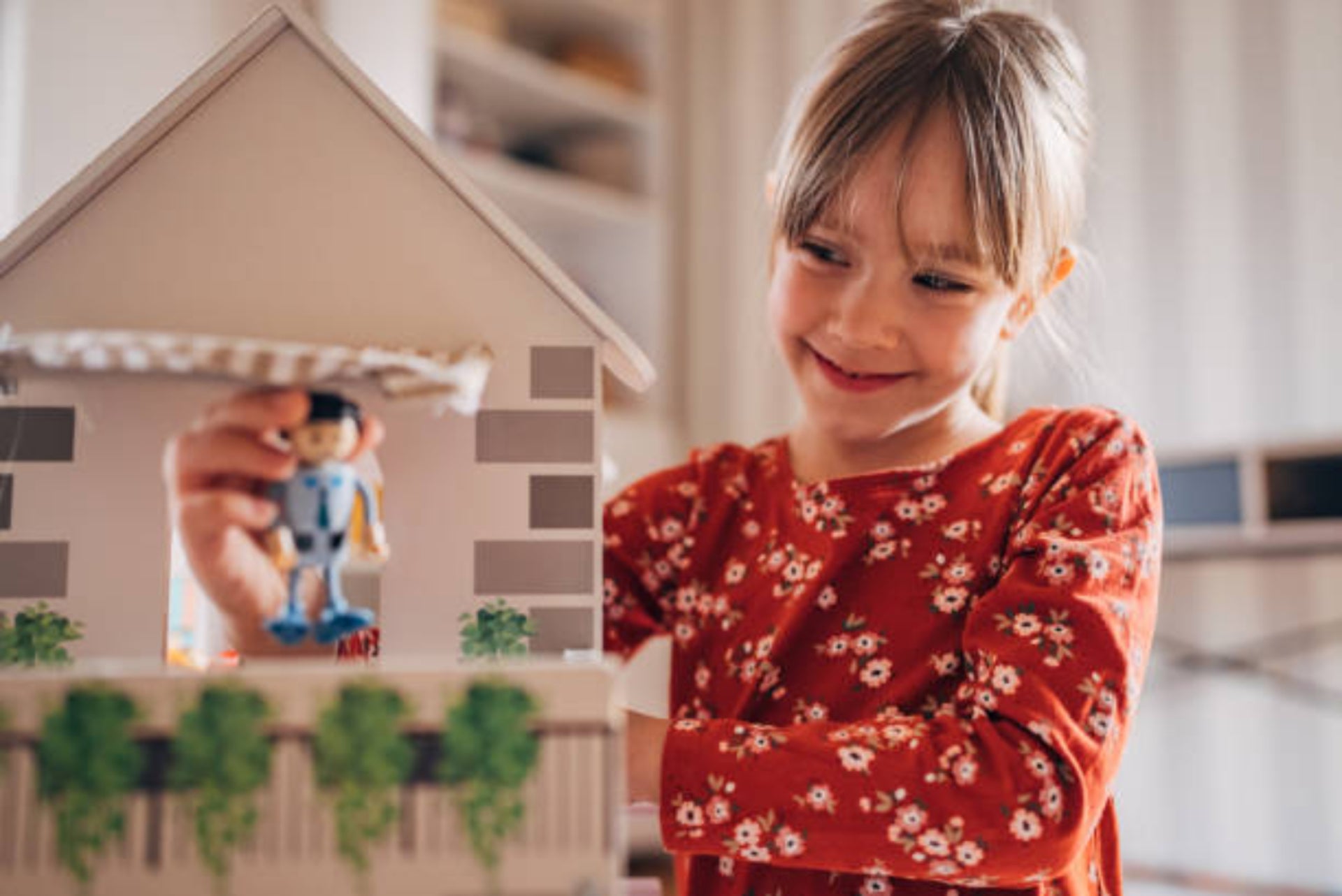 Girl playing with dollhouse