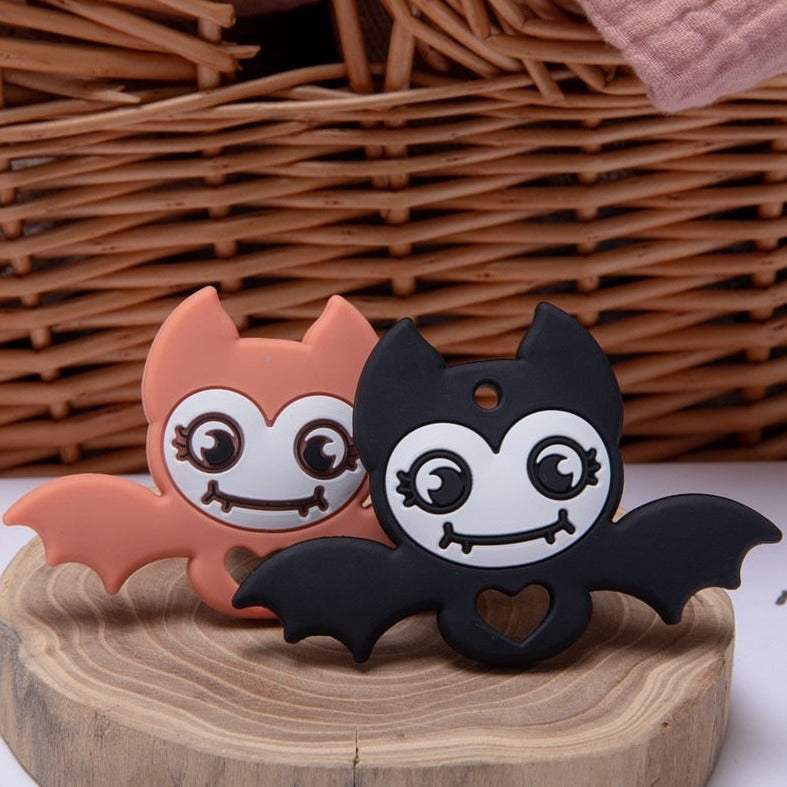 Halloween Series Silicone Baby Teethers shaped like a skull, pumpkin, and bat on a wood stump, designed for teething comfort and entertainment. Made from BPA-free, food-grade silicone.