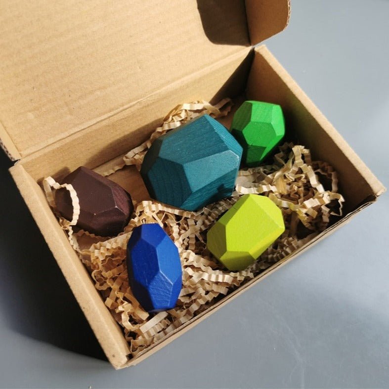Montessori Large Wooden Balancing Stones in a box, featuring various shapes for tactile play, promoting balance and spatial awareness through stacking and creative exploration.