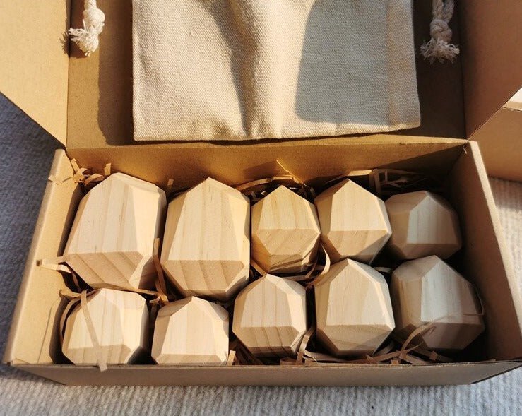 Montessori Large Wooden Balancing Stones in a box, showcasing various wood shapes for child-led play, fostering balance and spatial awareness through stacking and exploration.