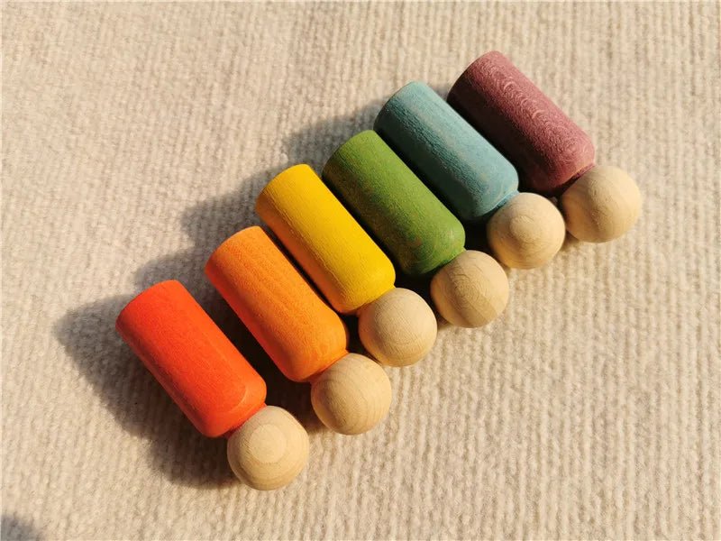 Montessori Rainbow Stacking Coins and Rings with Peg Dolls, featuring various wooden pegs, designed to enhance fine motor skills and imaginative play for toddlers.