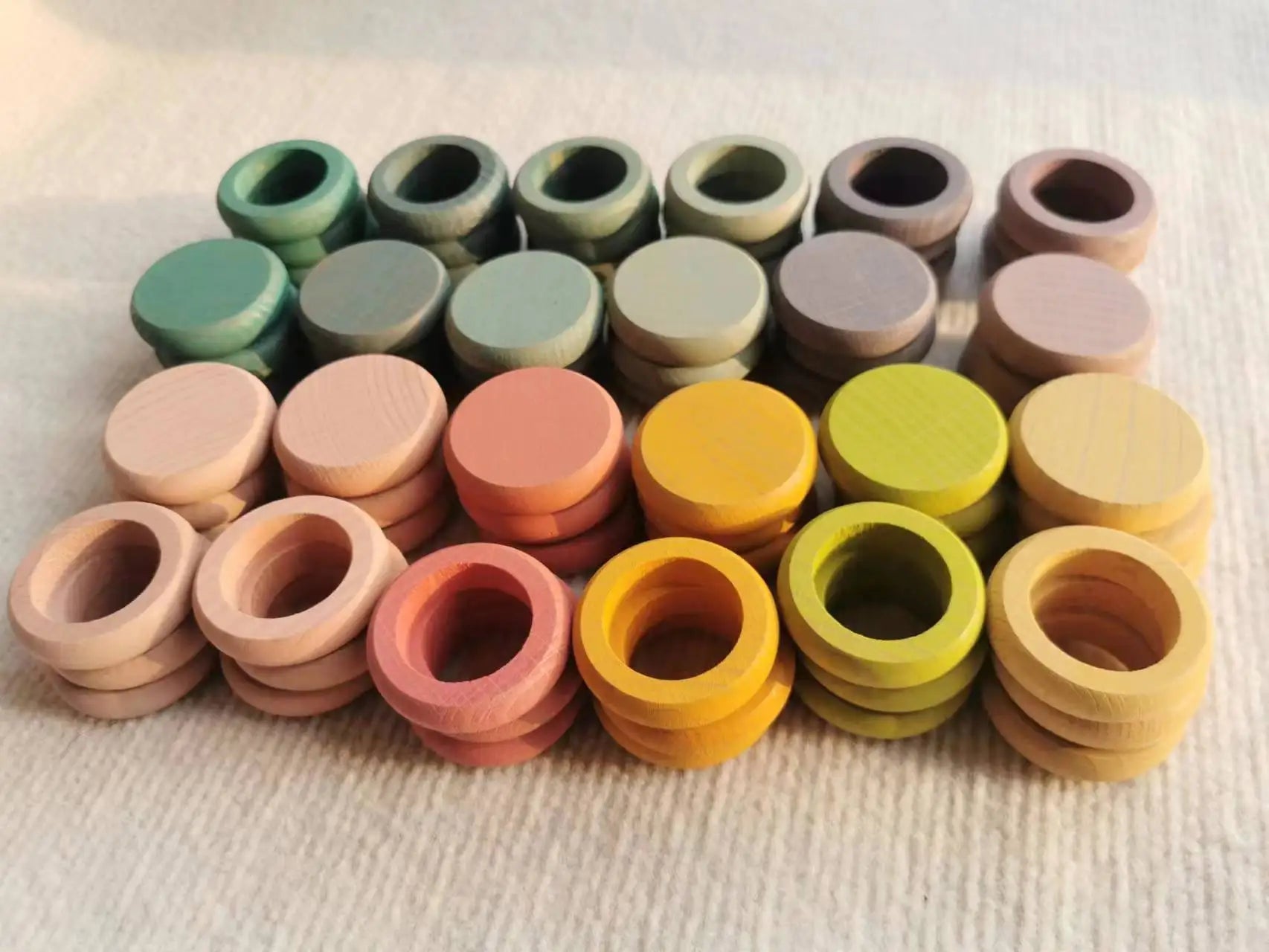 Montessori Rainbow Stacking Coins and Rings with Peg Dolls by Bajo, showcasing colorful wooden circles and rings, designed to enhance fine motor skills and imaginative play.