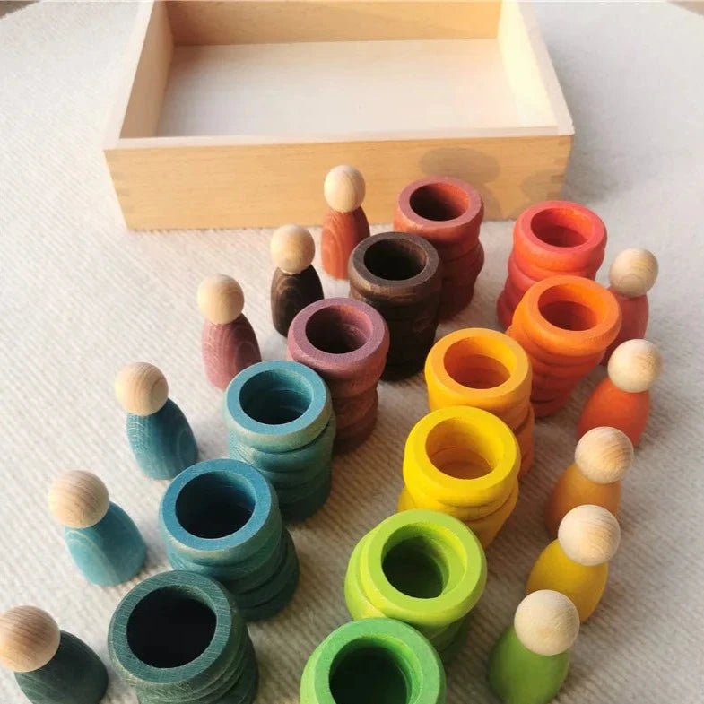 Montessori Rainbow Stacking Coins and Rings with Peg Dolls by Bajo, featuring wooden stackable coins, rings, and peg dolls for fine motor skill development.