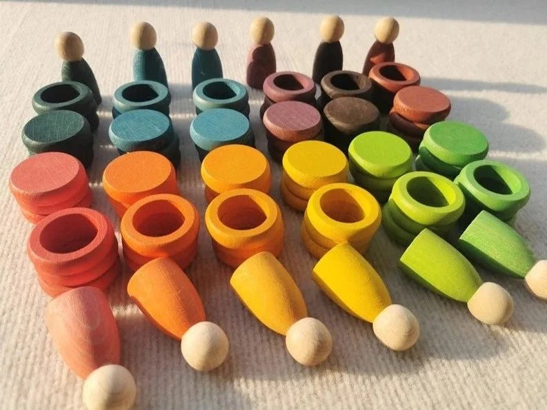 Montessori Rainbow Stacking Coins and Rings with Peg Dolls, featuring beech wood figures and rings, designed to develop fine motor skills and imaginative play for children.