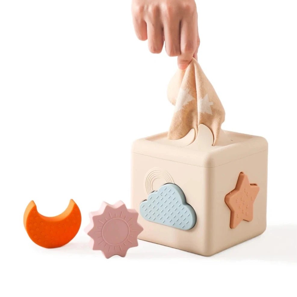 Hand holding cloth from Montessori Silicone Tissue Box, featuring interactive shapes for cognitive skill development in children.