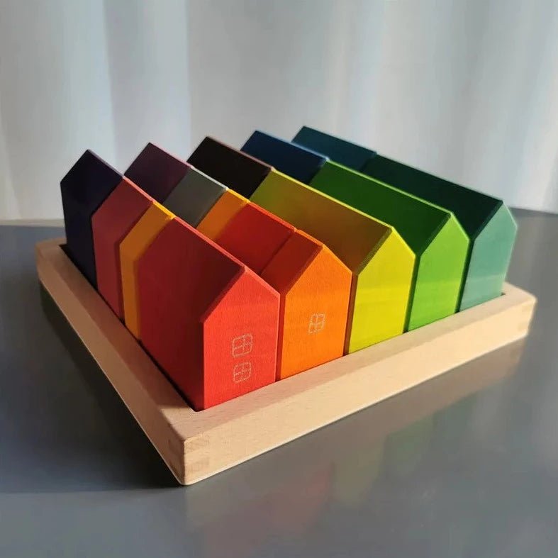Montessori Wooden Rainbow House Blocks on a table, showcasing colorful wooden houses for creativity and learning, aligning with Montessori principles from Oliver & Company Montessori Toys.
