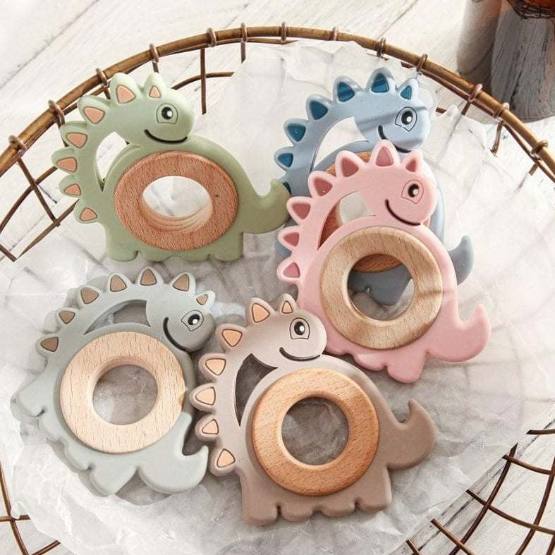 Wood and Silicone Dinosaur Teether in a basket, featuring adorable dinosaur shapes, designed to soothe babies' gums and stimulate sensory play.
