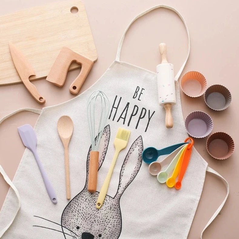 Wooden and Silicone Kitchenware Sets for kids, featuring a white apron with utensils and a cutting board, encouraging imaginative culinary play and skill development.