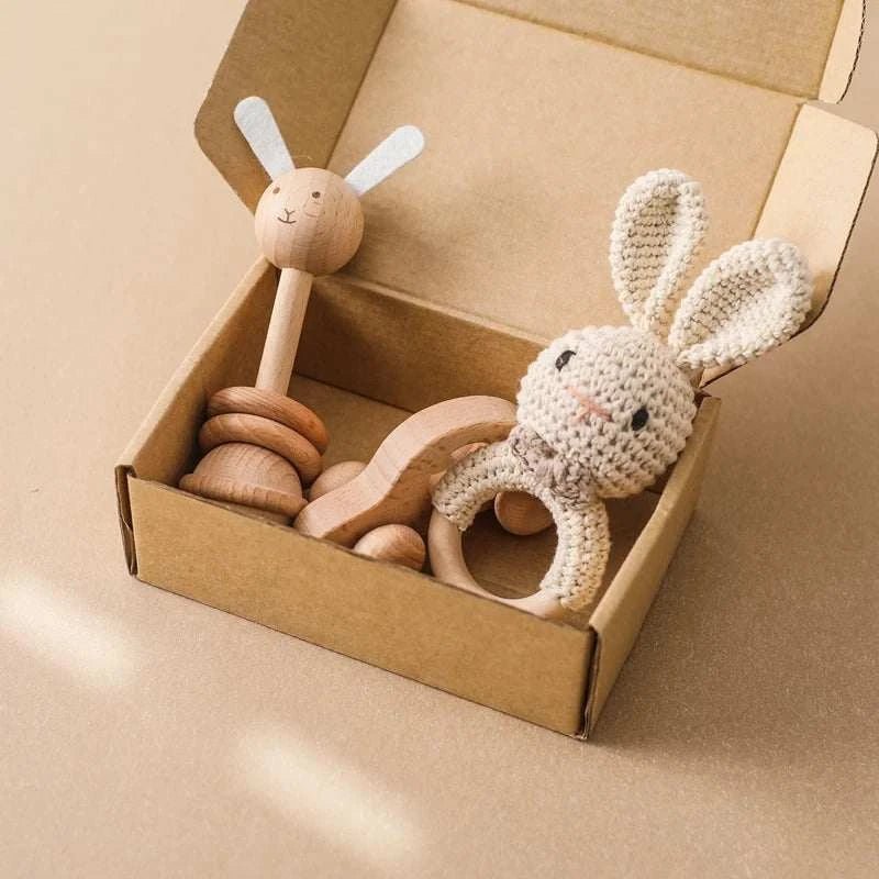 Woodland Friends Crochet and Wood Rattle Set featuring a crocheted bunny toy, a wooden ring with knitted cover, and a wooden stick rattle in a box.